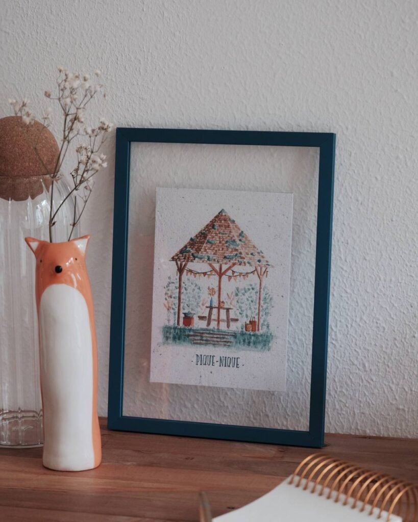 Illustration d’une boutique en ligne présentant des tirages limités d’aquarelles signées et numérotées, emballées à la main avec soin sur du papier recyclé.